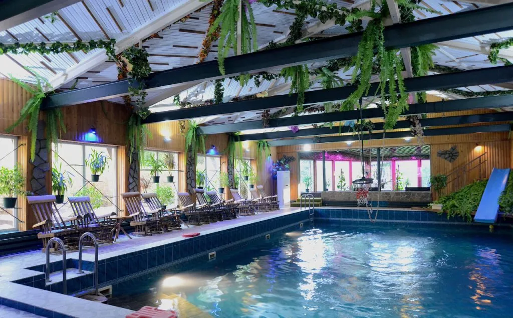 Современная внутренняя территория с бассейном, окруженная зеленью и уютными шезлонгами, идеально подходит для отдыха и релаксации в арт-отеле Ве Арт Ресорт.