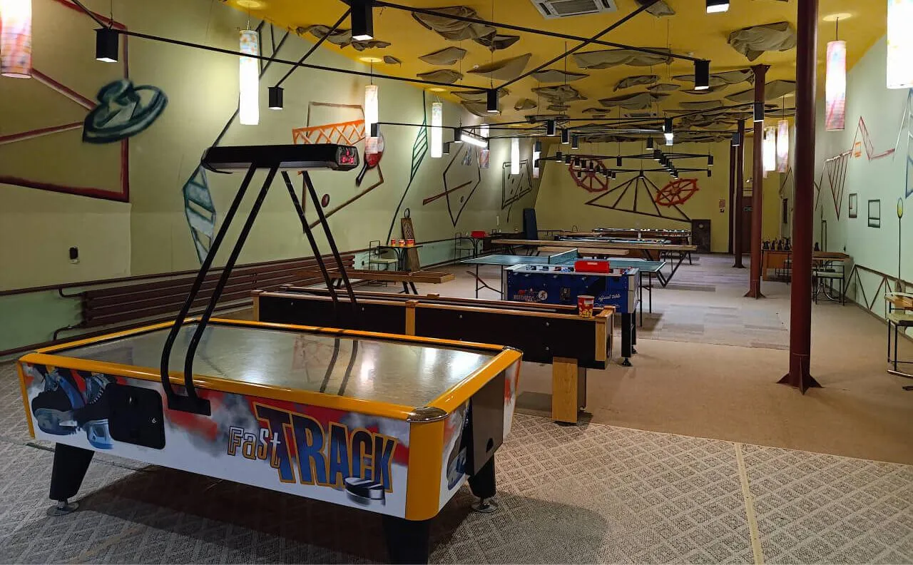 игровая комната с настольными играми, аэрохоккеем и танковым столом в VE Art Resort, Подмосковье уютное место для отдыха и развлечений.