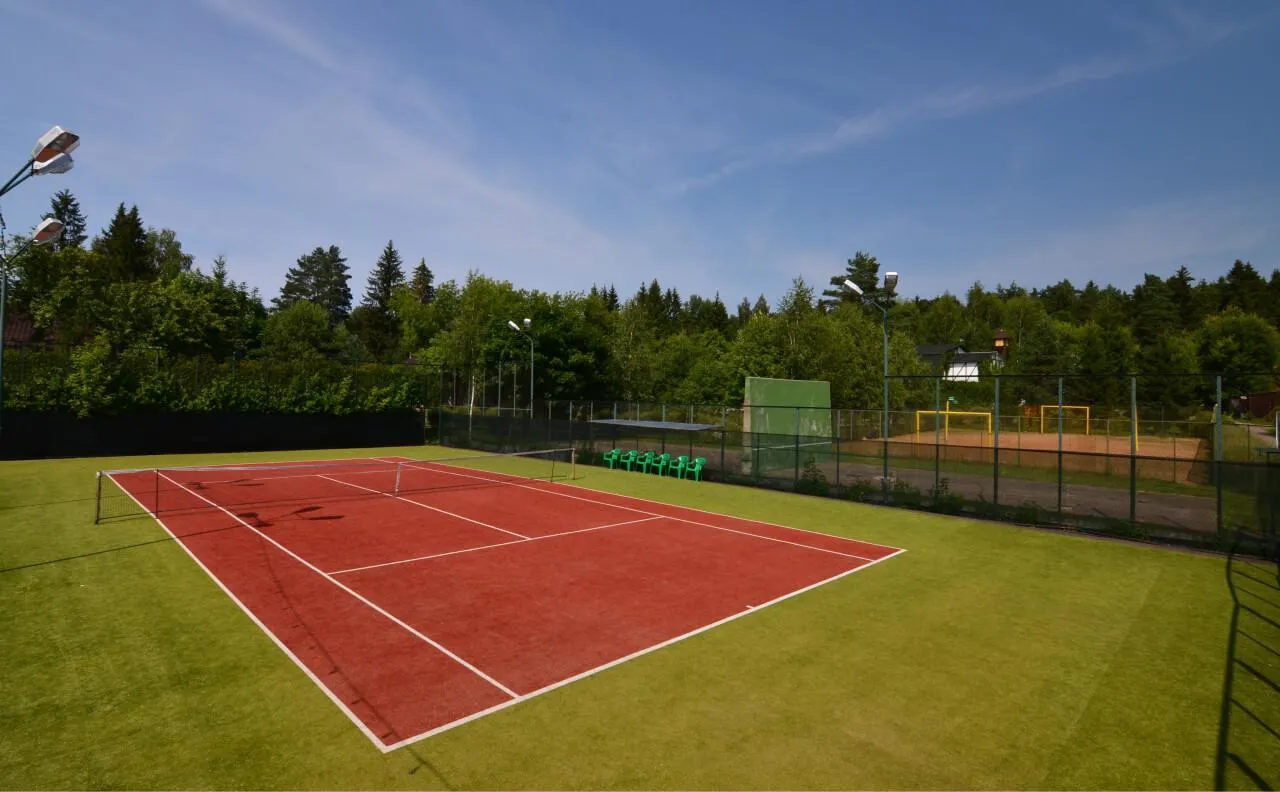 Уличный теннисный корт на территории ВЕ Art Resort, окружённый зеленью и густым лесом, предлагает отличные условия для активного отдыха в Подмосковье.