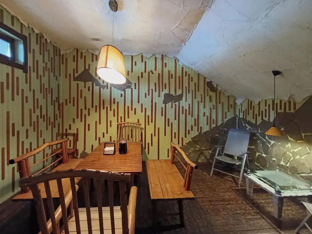 Уютная комната с деревянной мебелью, декоративной стеной и теплым освещением в арт-отеле ВЕ Art Resort в Подмосковье. Идеальное место для отдыха и расслабления.