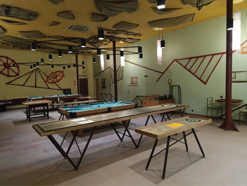 Уютная игровая комната в ART отеле Вэ Арт Резорт с бильярдом и настольными играми, современный дизайн и теплое освещение создают комфортную атмосферу для отдыха и развлечений.