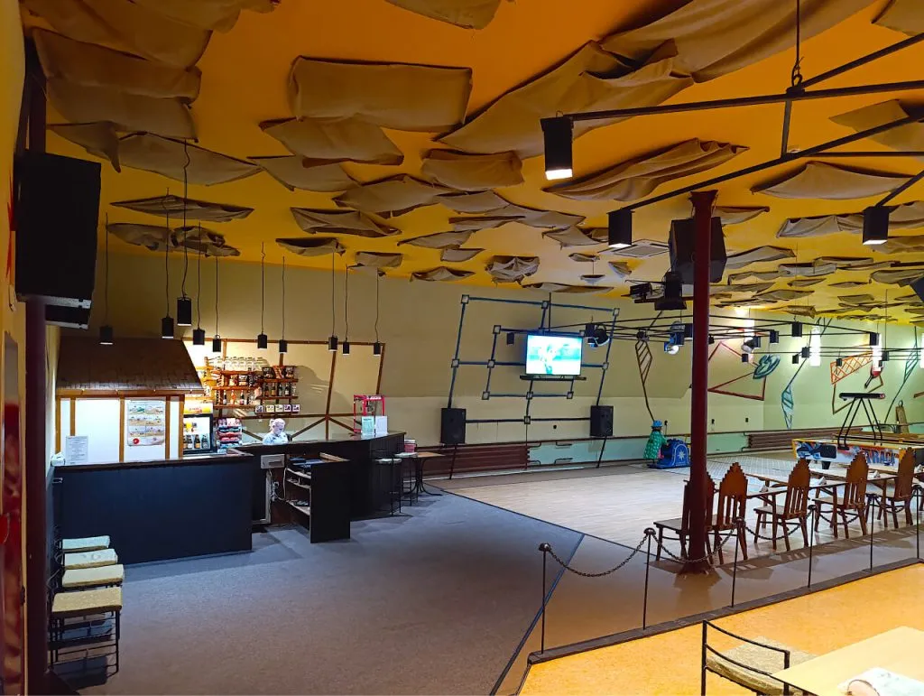 уютный зал с оригинальным дизайном, мягким освещением и креслами для отдыха, в центре есть барная стойка и зона для развлечений, сервис высокого уровня для отдыха в Подмосковье.