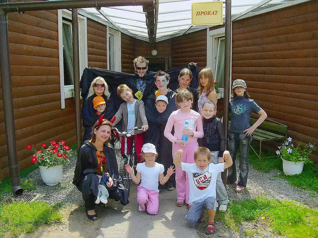 Прокат игры для детей на улице у арендованного коттеджа или дома в Подмосковье. Веселая компания детей и взрослых, прогулка на свежем воздухе, цветы в горшках, яркое настроение.