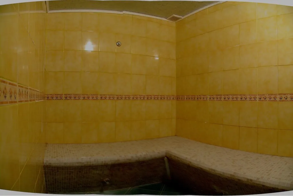 Релакс-зона в банном комплексе VE Art Resort, Подмосковье, с желтыми керамическими плитками и мягкой каменной лавкой. Атмосфера уюта и спокойствия.