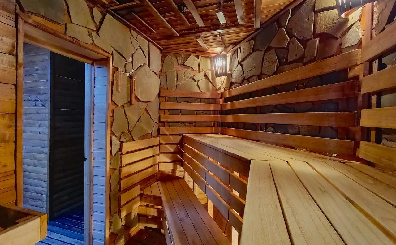 Банный комплекс с деревянными стенами и мягким освещением, предназначенный для релаксации и отдыха в Подмосковье. Идеальное место для восстановления сил и проведения приятного времени.