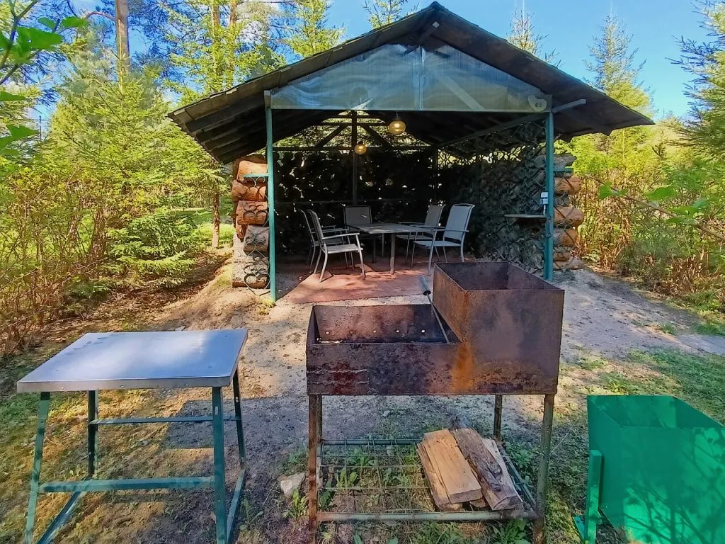 Уютная беседка в лесу рядом с VE Art Resort, окруженная зеленью деревьев, оборудована столом и стульями для отдыха на природе. Идеальное место для relax и приятных посиделок в Подмосковье.