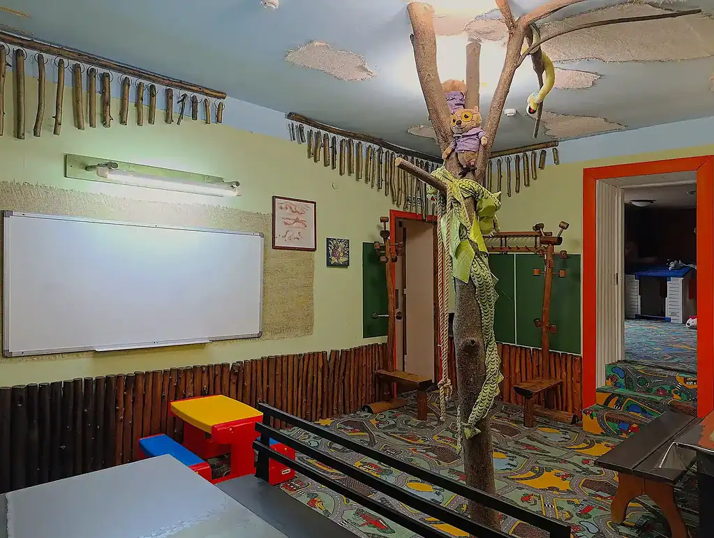 Детская игровая комната с деревом, игрушками и яркими элементами дизайна, идеально для отдыха с детьми в арт-отеле VE Art Resort в Подмосковье.