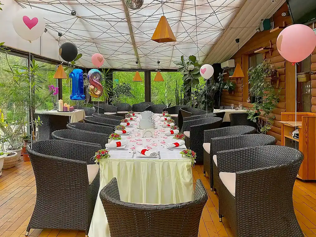 Современная уютная зона для проведения праздников и мероприятий в арт-отеле VE Art Resort, окруженная зеленью, с праздничной оранжировкой и декором.