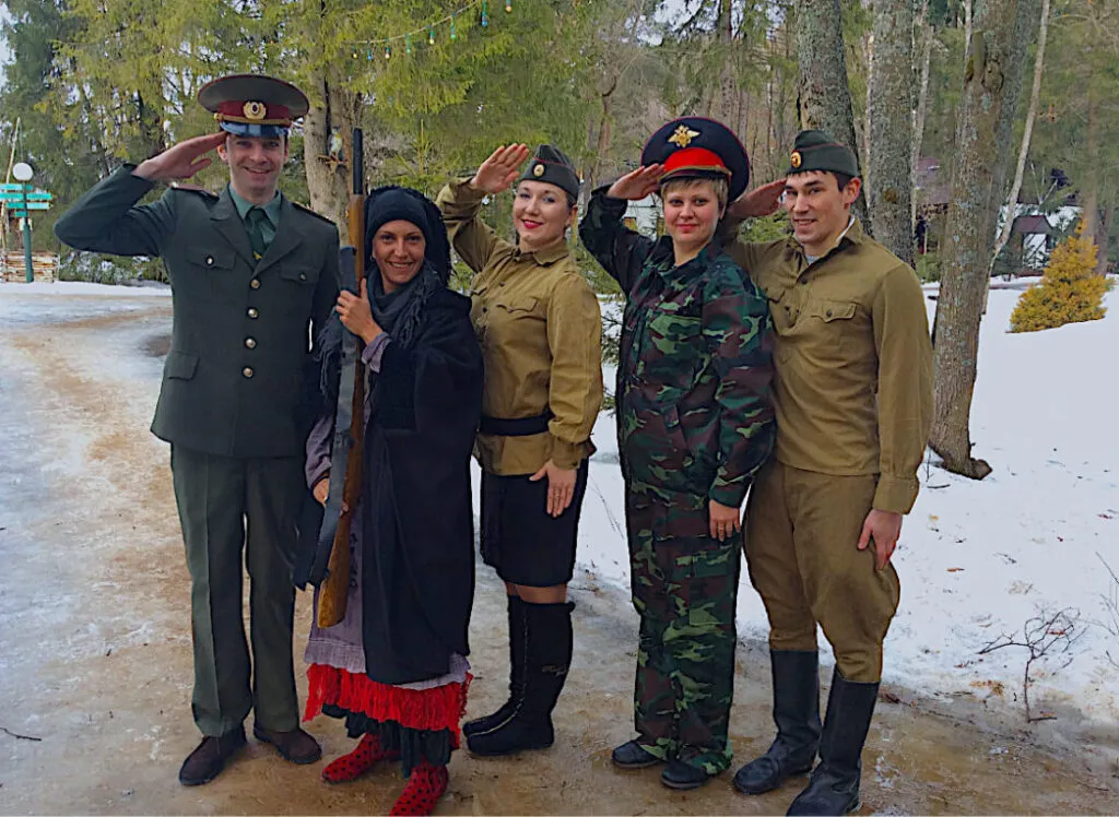 Мастера в военной форме на прогулке зимой на территории VE Art Resort. Люди позируют, улыбаются и поздравляют друг друга с праздником.