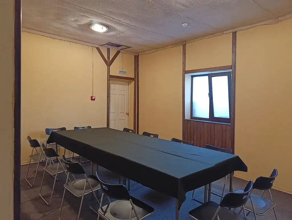 Комната для совещаний в VE Art Resort, уютное помещение с большим столом и стульями, оформленная в тёплых тонах, идеально подходит для деловых мероприятий и встреч на природе.