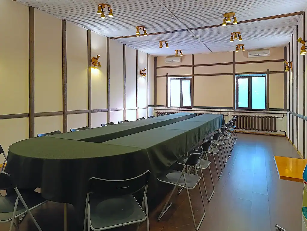 Современный конференц-зал для мероприятий в VE Art Resort, Подмосковье, с длинным столом, удобными стульями, светлыми стенами и окнами для естественного освещения.