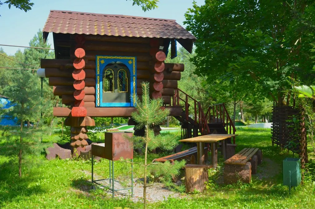 Уютный деревянный домик в зелени с лестницей, окружённый деревьями в природной зоне подмосковного отеля VE Art Resort.