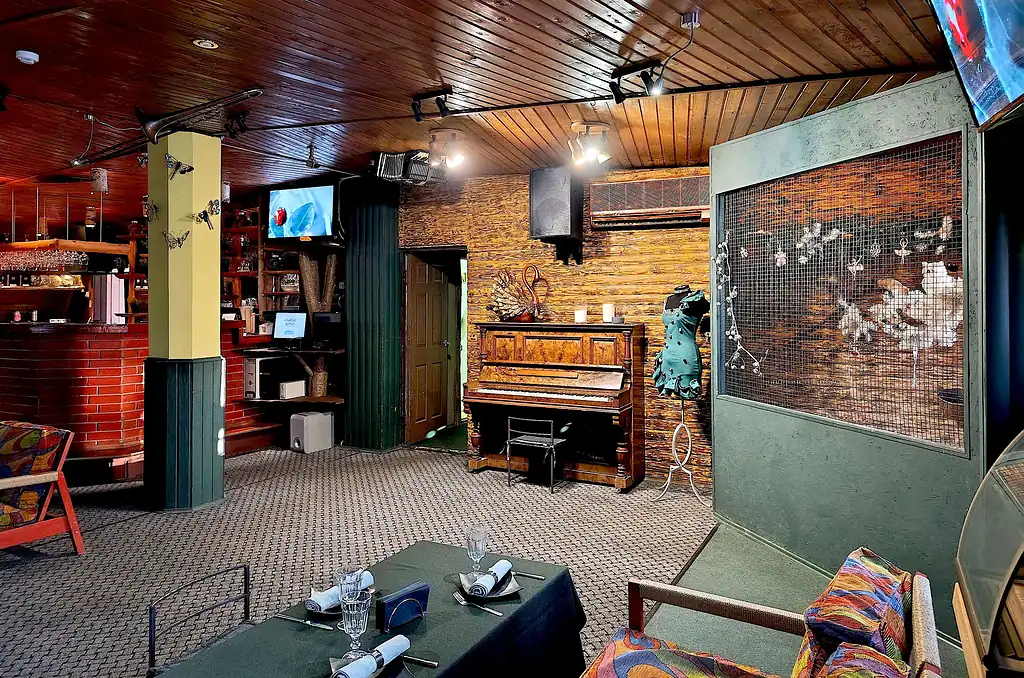 Уютный интерьер ресторана VE Art Resort в Подмосковье с деревянной отделкой, музыкальной зоной и уютной атмосферой для отдыха и вкусной еды.