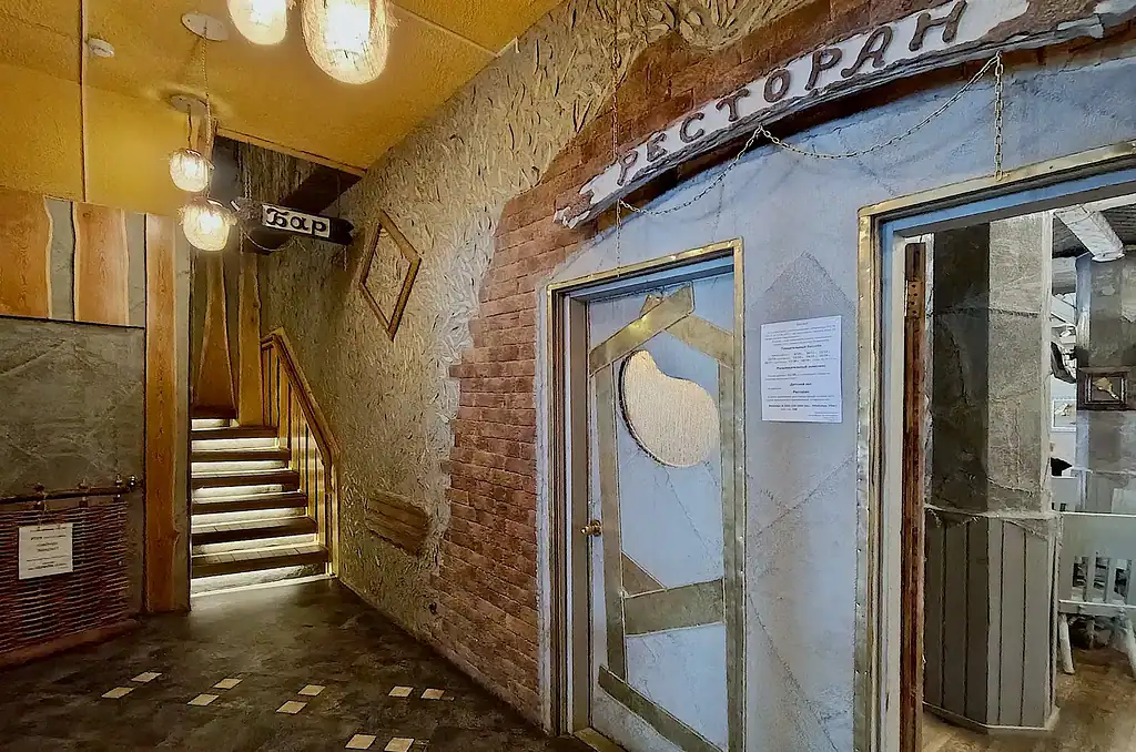 Уютный интерьер арт-отеля в Подмосковье с лестницей и декоративными светильниками, создающими теплую атмосферу отдыха и уюта для гостей.