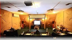 Современная уютная аудитория для мероприятий в арт-отеле VE Art Resort, оформленная в теплом стиле с проектором и цветочными композициями, готова к проведению корпоративных и частных встреч.