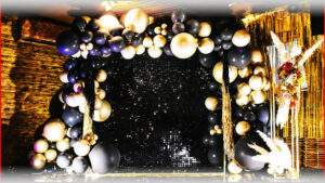 балансировка из черных, белых и золотых воздушных шаров для фотозоны, праздничное оформление, темное заднее освещение, украшение мероприятия, стильный декор, корпоративный или частный праздник.