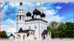 Белая церковь с черными куполами и золотыми крестами на фоне голубого неба и зеленых деревьев. Отличное место для отдыха в Подмосковье, предлагает комфортный отдых и живописные виды.